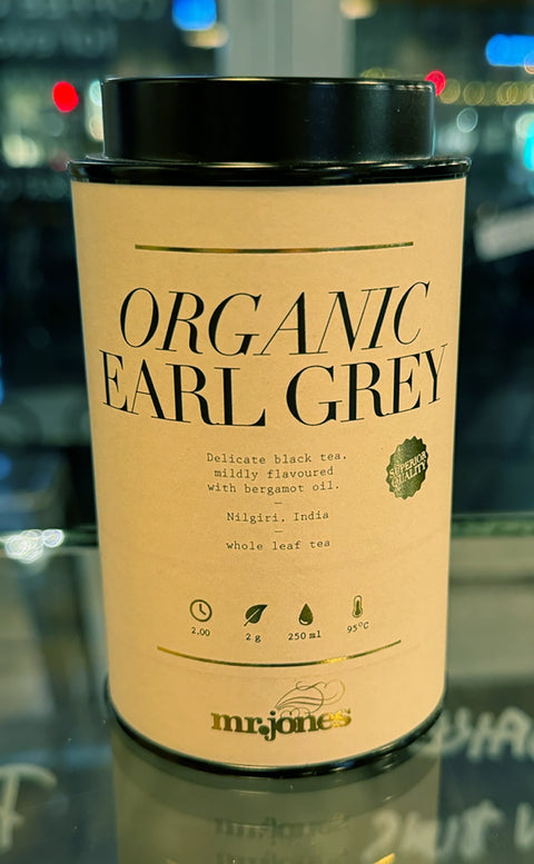 Canister of Mr. Jones Organic Earl Grey tea with branding on a reflective surface.