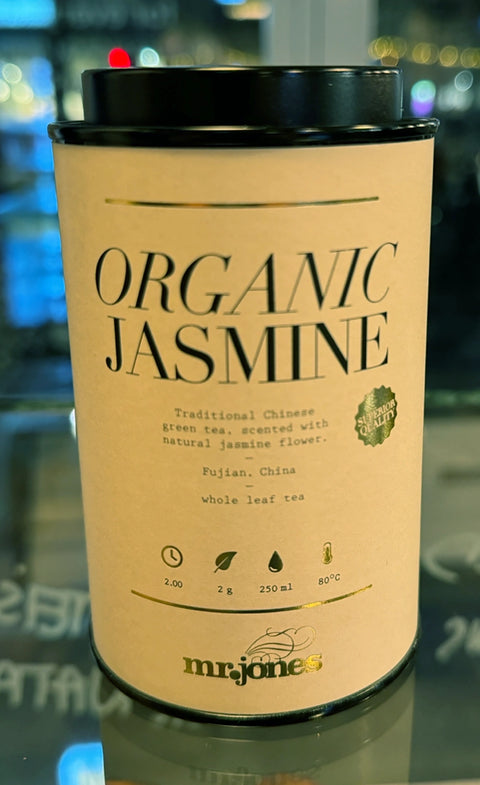 Packaging of Organic Jasmine tea from Mr Jones on a reflective surface with blurred background